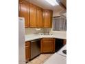Functional kitchen features a stainless-steel dishwasher, oak cabinets, and tile flooring at 3339 W Shaw Butte Dr, Phoenix, AZ 85029