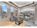 Bright living room with stone accent walls, arched windows, and comfortable seating area at 3675 N 59Th Pl, Phoenix, AZ 85018