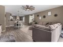 Open-concept living room featuring tile flooring, a ceiling fan, and comfortable seating with view of the kitchen at 37384 W Prado St, Maricopa, AZ 85138