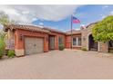 Charming single-story home with an American flag, manicured landscaping, brick accents, and a two-car garage at 3816 E Expedition Way, Phoenix, AZ 85050