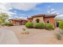 Attractive desert-landscaped home with colorful exterior, tile roof, and an attached garage at 3816 E Expedition Way, Phoenix, AZ 85050