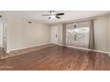 Open living room with wood floors, ceiling fan, and a front door view, offering a welcoming space at 4158 E Crescent Ave, Mesa, AZ 85206
