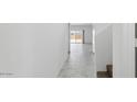 Bright hallway with tile flooring leading to an outdoor patio, with staircase to the right at 5075 E Umber Rd, San Tan Valley, AZ 85143