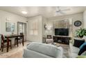 Living room featuring tile floors, a ceiling fan, a sofa, and access to the dining area at 5303 N 7Th St # 118, Phoenix, AZ 85014
