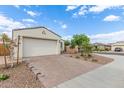 Single-story home with two-car garage featuring a brick driveway and desert landscaping at 5312 W Hardtack Trl, Laveen, AZ 85339