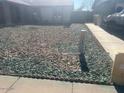 The low maintenance front yard features decorative rock landscaping and sidewalk access at 6231 W Zoe Ella Way, Glendale, AZ 85306