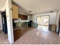 Open kitchen and dining area with vintage tiling, cabinetry, and countertops at 7961 W Campbell Ave, Phoenix, AZ 85033