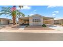 Charming single-story home with covered parking, mature landscaping, and an American flag at 8103 E Southern Ave # 205, Mesa, AZ 85209