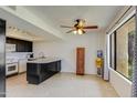 Bright kitchen with black cabinetry, a center island, and a tiled floor at 8827 N New World Dr, Glendale, AZ 85302