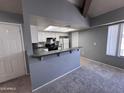 Living room featuring an open floor plan, breakfast bar, and view into the kitchen area at 9209 N 59Th Ave # 206, Glendale, AZ 85302