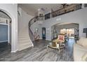 Spacious living room featuring a curved staircase, soaring ceilings, and luxury vinyl flooring at 15953 W Custer Ln, Surprise, AZ 85379