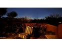 Inviting patio with a cozy chair, potted plants, and a view of the city lights at night at 1607 W Pearce Rd, Phoenix, AZ 85041