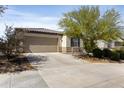 Single-story home featuring desert landscaping, a two-car garage, and a spacious driveway on a sunny day at 19984 W Washington St, Buckeye, AZ 85326