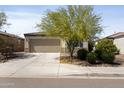 Single-story home with desert landscaping, a two-car garage, and a spacious driveway on a sunny day at 19984 W Washington St, Buckeye, AZ 85326