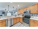 Bright kitchen featuring stainless steel appliances, wooden cabinets, stylish countertops, and pendant lighting at 2101 S Meridian Rd # 146, Apache Junction, AZ 85120
