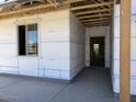 The entryway showcases the home's construction with an unfinished exterior and smooth concrete porch at 24083 W Bowker St, Buckeye, AZ 85326