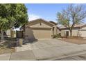 A well-kept single-story home featuring a two-car garage, mature landscaping, and a cozy front entrance at 2932 N 115Th Ln, Avondale, AZ 85392