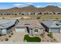 Aerial view of a modern home with a three-car garage and mountain views at 32268 N 133Rd Ln, Peoria, AZ 85383