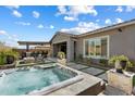 Beautiful backyard with a hot tub, outdoor kitchen, and tiled patio at 32268 N 133Rd Ln, Peoria, AZ 85383