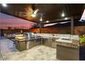 Beautiful covered outdoor kitchen featuring stainless steel appliances and a stone countertop at 32268 N 133Rd Ln, Peoria, AZ 85383