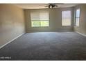 Spacious living room with plush carpeting and a ceiling fan offers comfort and style for relaxing or entertaining at 4136 N 113Th Dr, Phoenix, AZ 85037