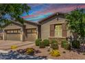 Beautiful single-story home showcasing a three-car garage and desert landscaping, with shuttered windows at 4361 S Electron --, Mesa, AZ 85212