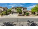 Two-story home featuring desert landscaping, a wide driveway, and neutral-tone exterior at 44566 W High Desert Trl, Maricopa, AZ 85139