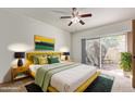 Cozy bedroom with a ceiling fan, sliding glass door to the backyard, and stylish decor at 6734 S Brittany S Ln, Tempe, AZ 85283