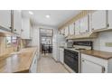 Efficient kitchen layout with white cabinets, wood countertops, and essential appliances at 8103 E Southern Ave # 154, Mesa, AZ 85209