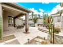 Beautiful backyard patio area featuring an outdoor fireplace, desert landscaping, and comfortable seating at 8220 E Mohawk Ln, Scottsdale, AZ 85255