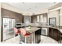 Modern kitchen with stainless steel appliances, a center island, and dark wood cabinetry at 8220 E Mohawk Ln, Scottsdale, AZ 85255