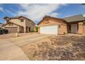 Home exterior showing a two-car garage, driveway, and low maintenance landscaping at 9167 N 73Rd Ln, Peoria, AZ 85345
