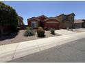 Single-story home with well-maintained landscaping, including desert plants and a mature shade tree at 10247 W Hilton Ave, Tolleson, AZ 85353