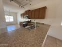 Open kitchen with granite countertops, stainless steel appliances, and ample cabinet space at 10247 W Hilton Ave, Tolleson, AZ 85353