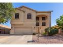 Two-story home with a two-car garage, neutral colors, and low-maintenance desert landscaping at 12571 W Clarendon Ave, Avondale, AZ 85392