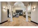 Open living space with travertine flooring, decorative columns, and a view into the living and dining areas at 1423 E Beverly Ln, Phoenix, AZ 85022