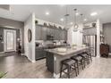 Modern kitchen features gray cabinets, granite countertops, stainless steel appliances, and a large island with seating at 16906 W Palm Ln, Goodyear, AZ 85395