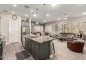 Open floor plan featuring kitchen island, living room with leather sofa, and bright windows at 16906 W Palm Ln, Goodyear, AZ 85395