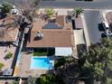 An aerial view of a home featuring a backyard pool, covered patio, and solar panels at 1720 E Intrepid Ave, Mesa, AZ 85204