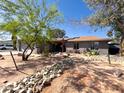 A charming home with desert landscaping and a rock-lined pathway to the front door at 1720 E Intrepid Ave, Mesa, AZ 85204