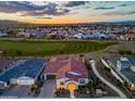 Stunning aerial view of the home with red tile roof, golf course, and mountain views at sunset at 17396 W Crawfordsville Dr, Surprise, AZ 85388
