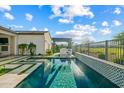 Spacious backyard with a stylish pool, outdoor kitchen, lush plants and beautiful golf course views at 17396 W Crawfordsville Dr, Surprise, AZ 85388