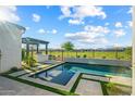 Stunning pool area with outdoor kitchen and serene golf course views offers the perfect relaxation spot at 17396 W Crawfordsville Dr, Surprise, AZ 85388