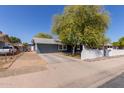 Charming single-story home featuring a well-maintained yard, mature trees and a classic white picket fence at 20816 E Duncan St, Queen Creek, AZ 85142