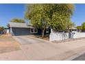 Charming single-story home featuring a well-maintained yard, mature trees and a classic white picket fence at 20816 E Duncan St, Queen Creek, AZ 85142
