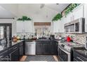 Modern kitchen features sleek black countertops, stainless steel appliances, and white cabinets at 288 E Baylor Ln, Gilbert, AZ 85296