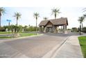 Community entrance with stone gate house, lush landscaping, and a beautifully paved brick street at 3306 E Jaeger Cir, Mesa, AZ 85213