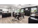 Open-concept dining area next to kitchen boasts a chic light fixture and view of a cozy fireplace at 4839 W Juniper Ave, Glendale, AZ 85306