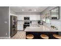 Bright and modern kitchen features white cabinets, stainless steel appliances, and a stylish breakfast bar at 4839 W Juniper Ave, Glendale, AZ 85306