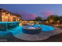 Relaxing backyard with a private pool, spa, outdoor bar and grilling area at 4876 N 207Th Ln, Buckeye, AZ 85396